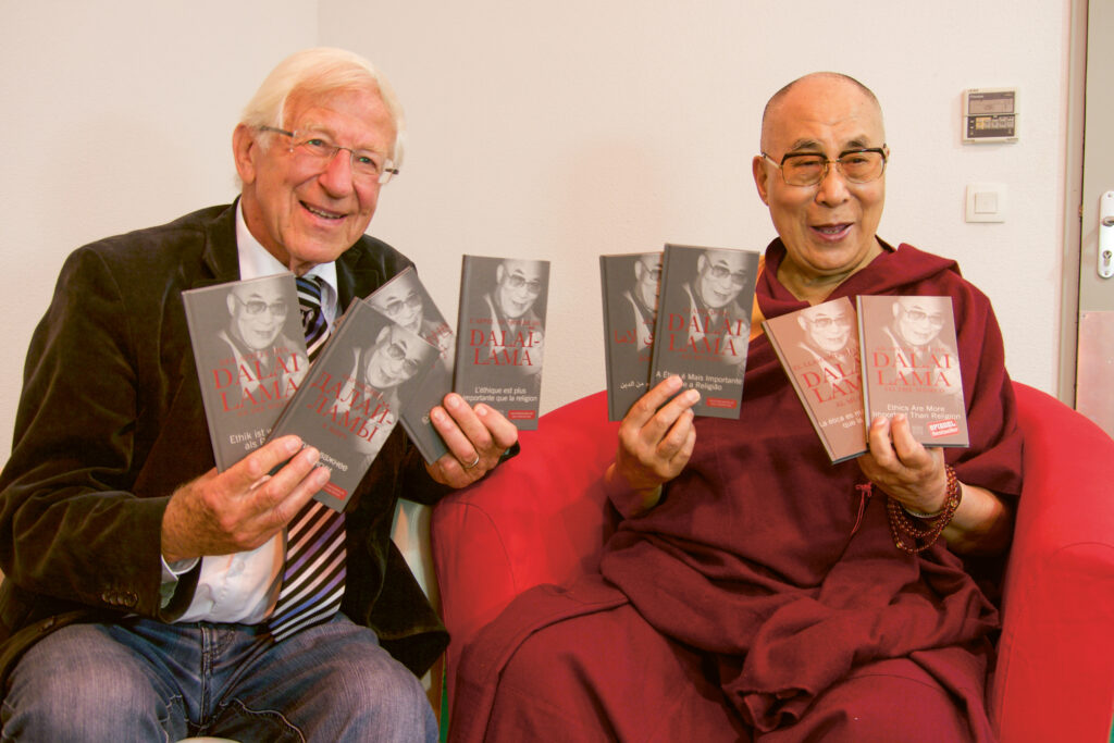 Der Dalai Lama mit dem Autor Franz Alt. Beide zeigen Bücher mit dem Titel Dalai Lama