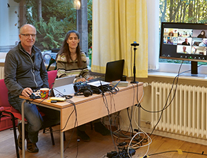 Vorschau Säkularer Dhamma: 1. internationales Hybrid-Retreat 2021, Jochen Weber und Saskia Graf am Schreibtisch, vor ihnen ein Bildschirm