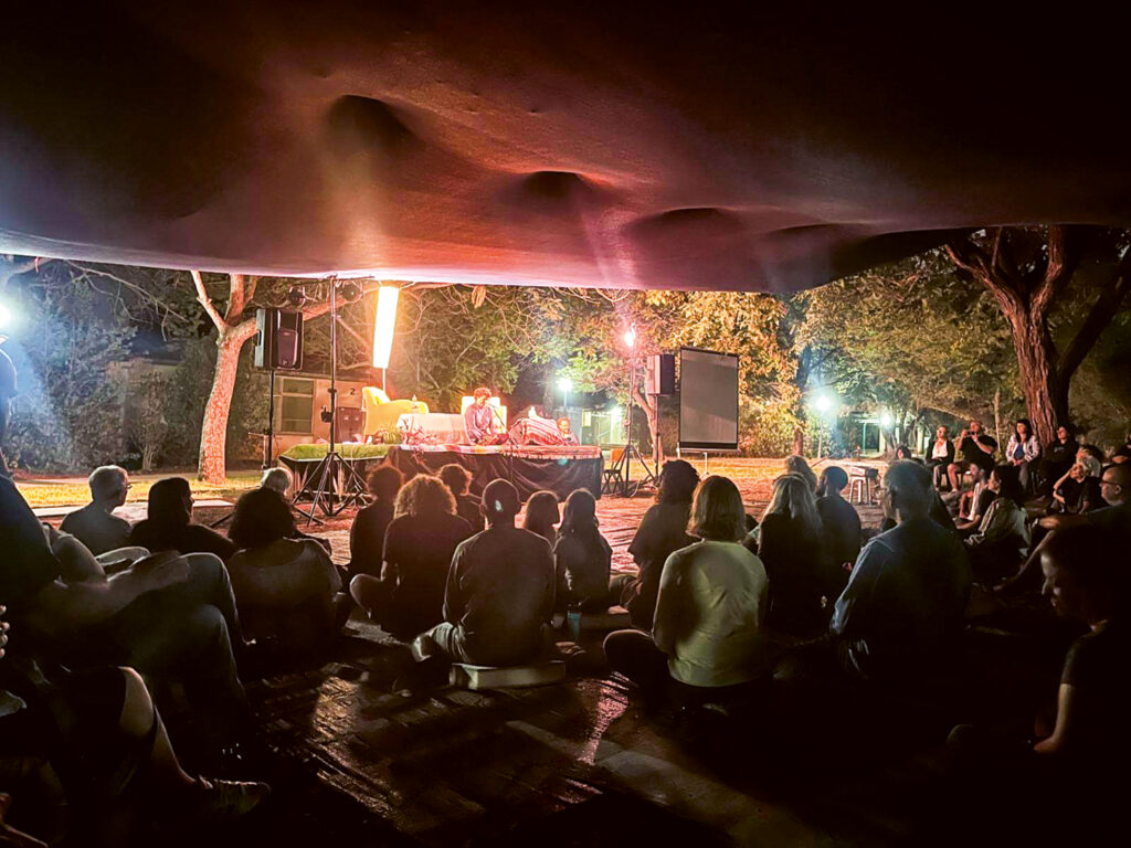 Tovana-Retreat im Kibbuz Ein Dor: Menschen im Meditationssitz in der beleuchteten Dunkelheit